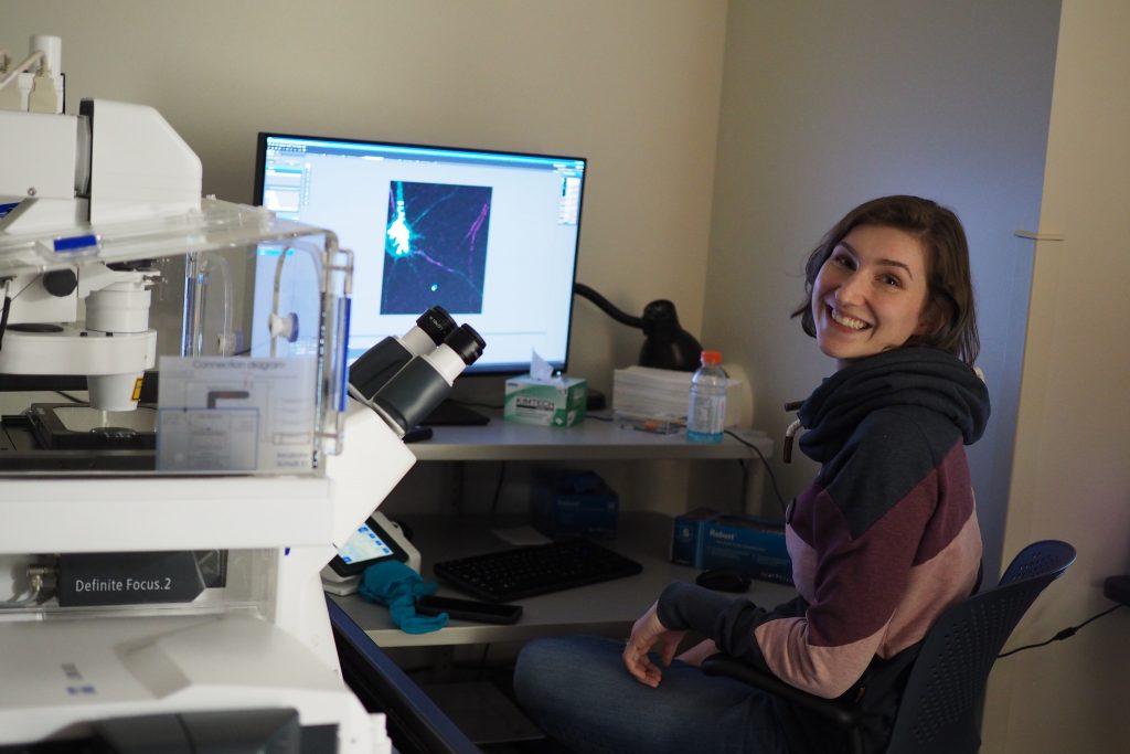Dr. Emma Watson-Roberts smiles for the camera while hard at work on the labs confocal microscope. 